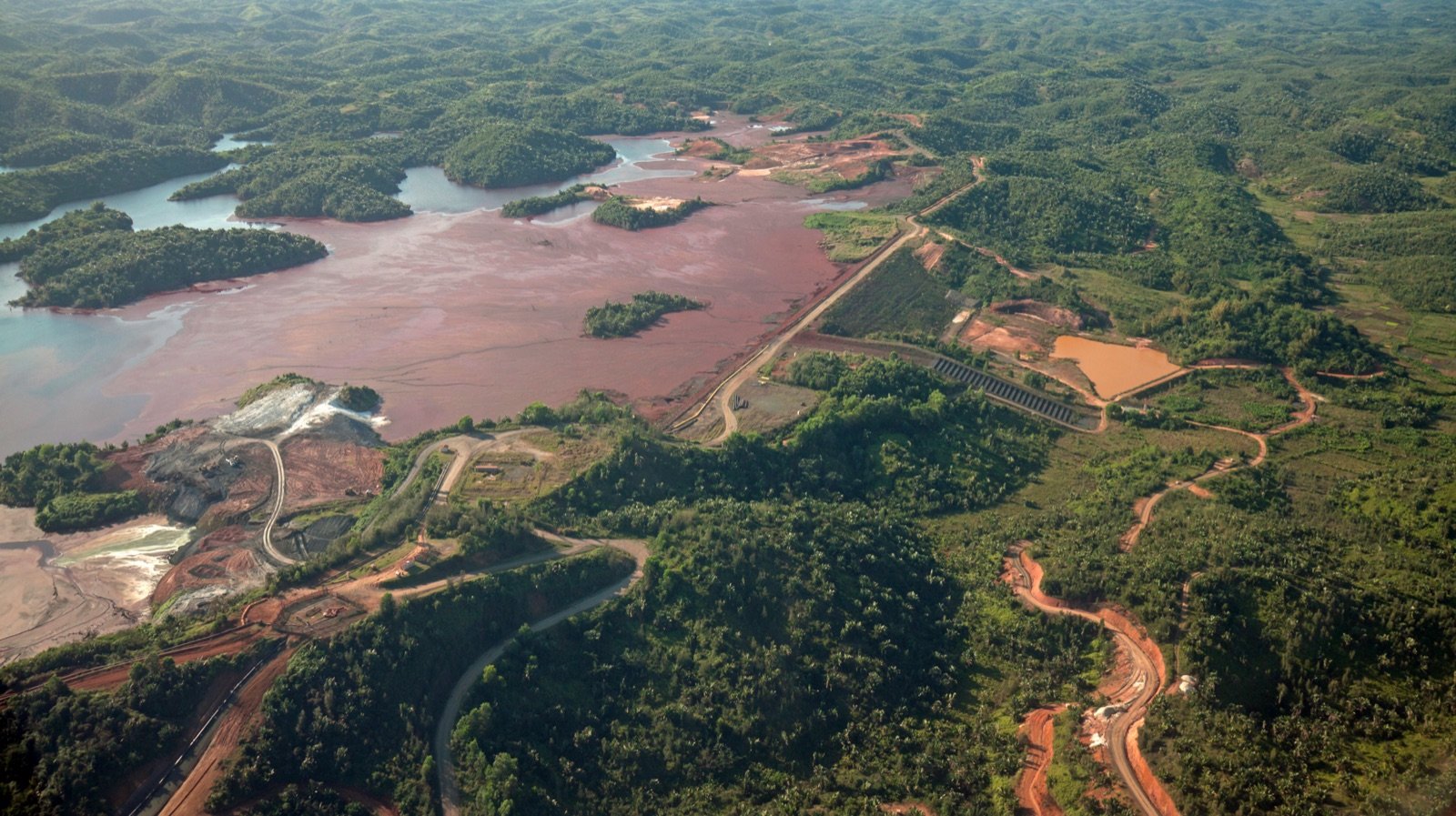 Vista aérea de un depósito de relaves mineros rodeado de vegetación